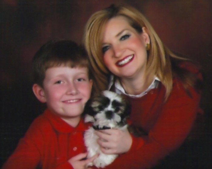A mother and son in a portrait with a Shih Tzu puppy