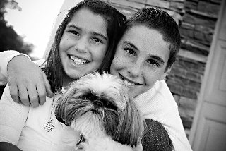 Two children holding a Shih Tzu